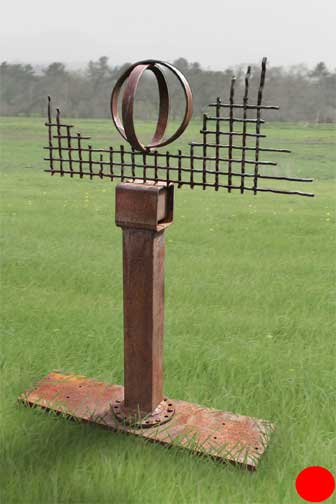 Metal sculpture - Broad metal base supports square pole with metal grate surrounding entwilned hoops